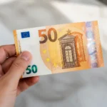 Billet de 50 euros presente par une main